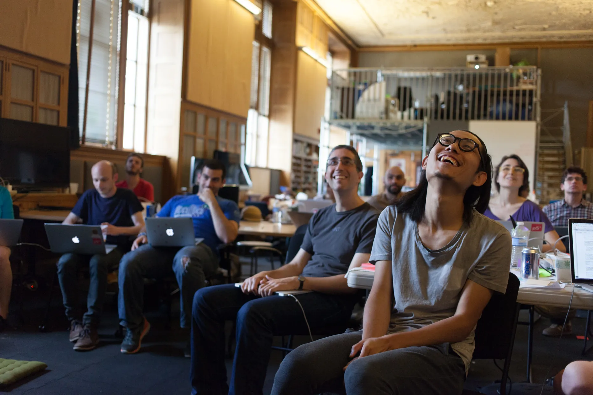 Participants attentively smile and listen to a presentation