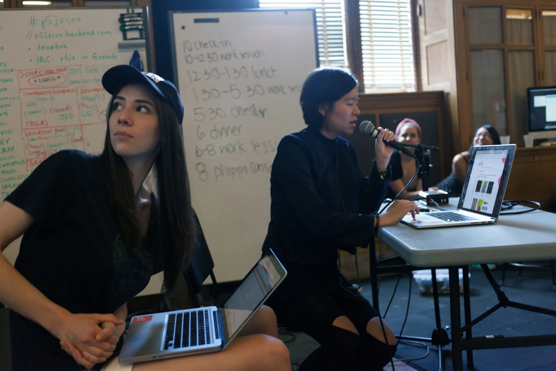 Woman reads about p5.js into a microphone to three female students